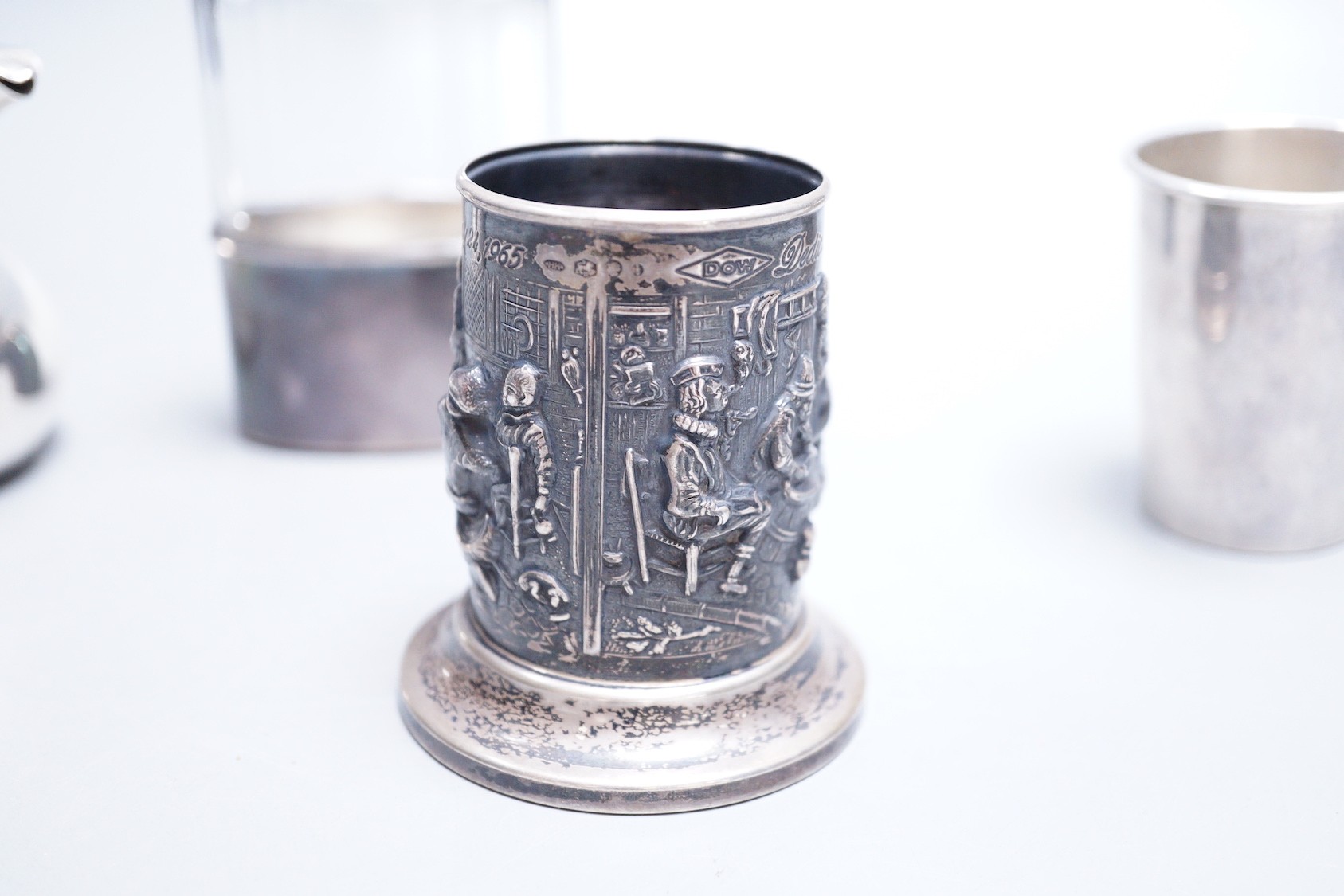 A Dutch embossed white metal cylindrical vase, 75mm, a French white metal small bachelor's hot water pot, an Italian 925 small beaker and a silver capped hip flask with plated cup.